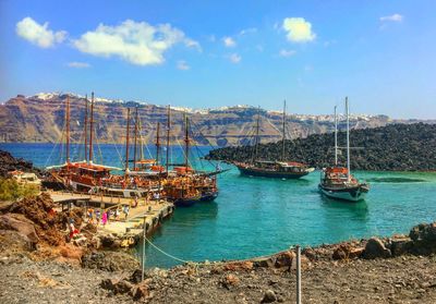 Sailboats moored on sea against sky