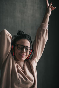 Portrait of smiling young woman holding eyeglasses