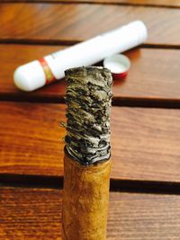 Close-up of burnt cigarette butt on wooden table