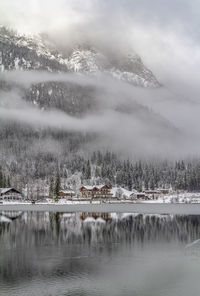 Scenic view of lake by snowcapped mountains against sky