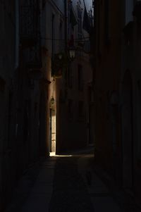 Narrow street amidst buildings at night