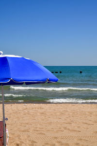 Scenic view of beach against clear blue sky