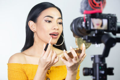 Portrait of young woman photographing