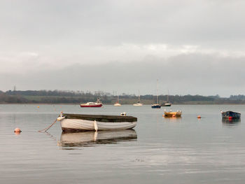 Boats moored in sea against sky