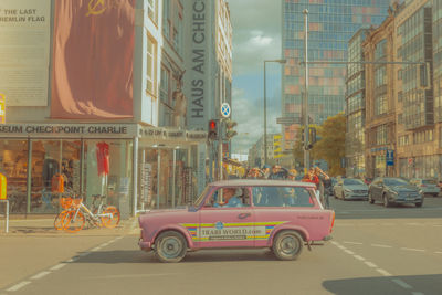 Vehicles on road by buildings in city