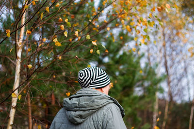 Rear view of man wearing hat against trees