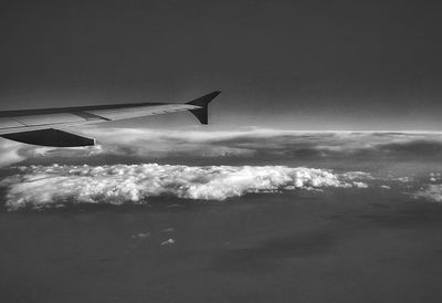 Airplane flying over sea against sky