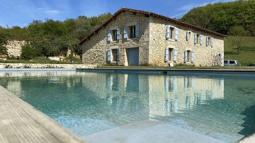 Swimming pool by lake against building