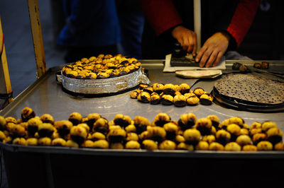 Midsection of vendor preparing food at market stall