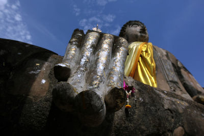 Low angle view of buddha statue against sky