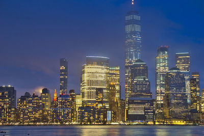 Illuminated buildings in city against sky