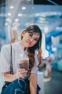 Portrait of a smiling young woman holding ice cream