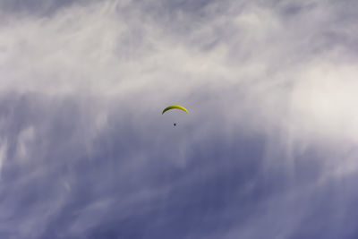 Low angle view of person paragliding against sky