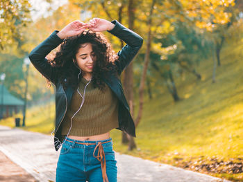 Young woman standing on footpath at park