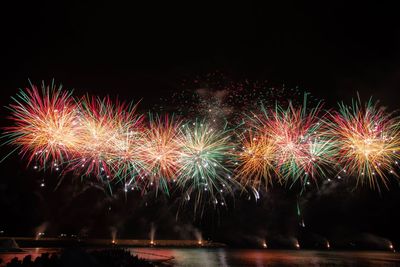 Low angle view of firework display against clear sky at night