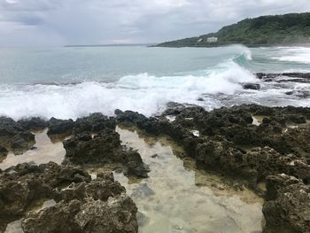 Scenic view of rocks on beach against sky