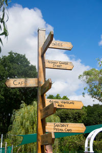 Low angle view of sign board against cloudy sky