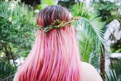 Rear view of woman with redhead wearing tiara while standing in park