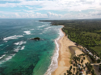 Aerial shot of a beach in the caribbean with turquoise water, white sand and palm trees