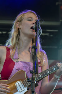 Portrait of young woman playing guitar