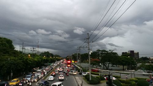Cars on city street against sky