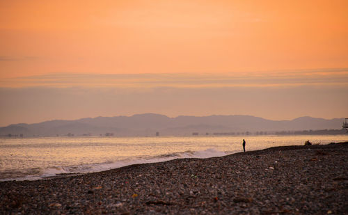 Scenic view of beach against sky during sunset