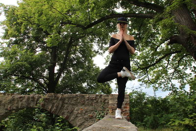 Low angle view of young man against trees