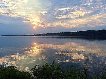 Scenic view of lake against sky at sunset