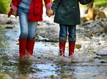 Low section of women standing in stream