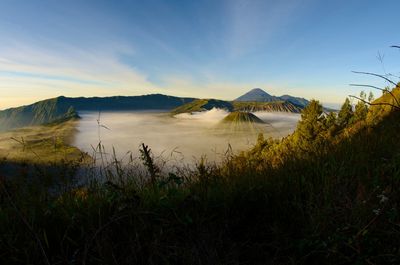 Scenic view of land and mountains against sky