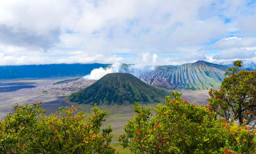 Scenic view of volcanic mountain against cloudy sky