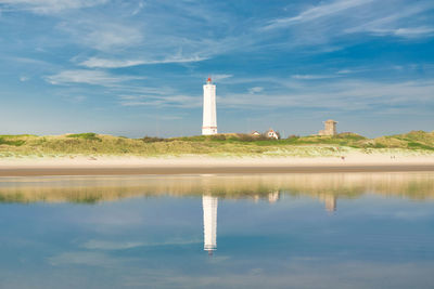 Lighthouse amidst buildings against sky