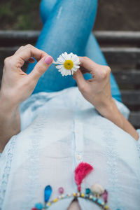 Midsection of woman holding daisy