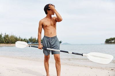 Rear view of shirtless man exercising in sea