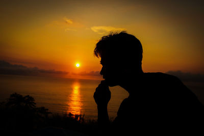 Portrait of silhouette man on beach against sky during sunset