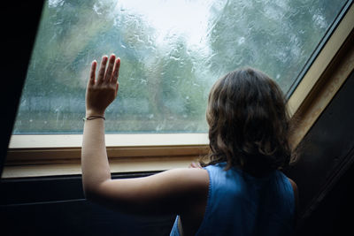 Rear view of boy in glass window