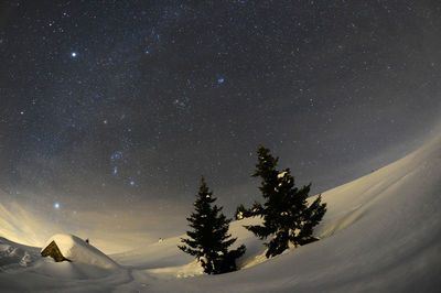 Scenic view of snowcapped mountain against sky at night