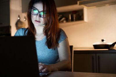 Woman working late on laptop at home