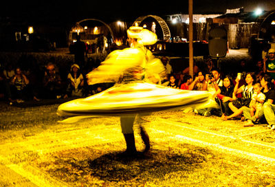 People in illuminated street at night