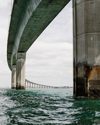 View of bridge over sea against cloudy sky