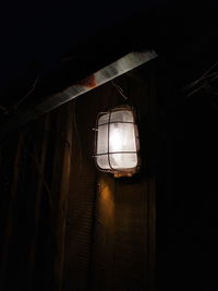 Low angle view of illuminated lamp hanging on ceiling