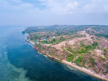 High angle view of sea by mountain against sky