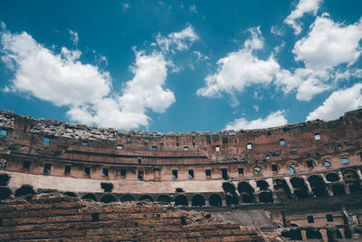 Low angle view of old ruins against cloudy sky