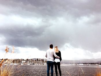 Rear view of couple standing against sky