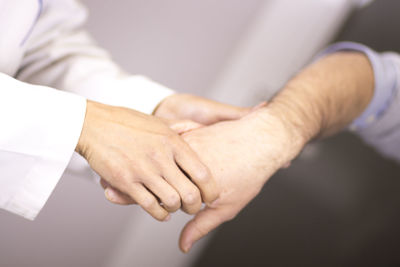 Midsection of doctor examining hand 