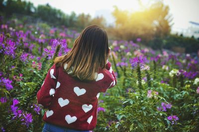 Woman holding flowers on field