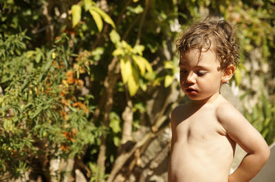 Boy standing against plants