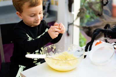 Side view of boy eating food at home