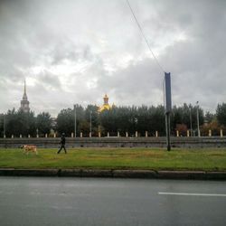 Built structure on landscape against cloudy sky