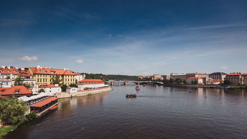 Townscape by river against sky in town